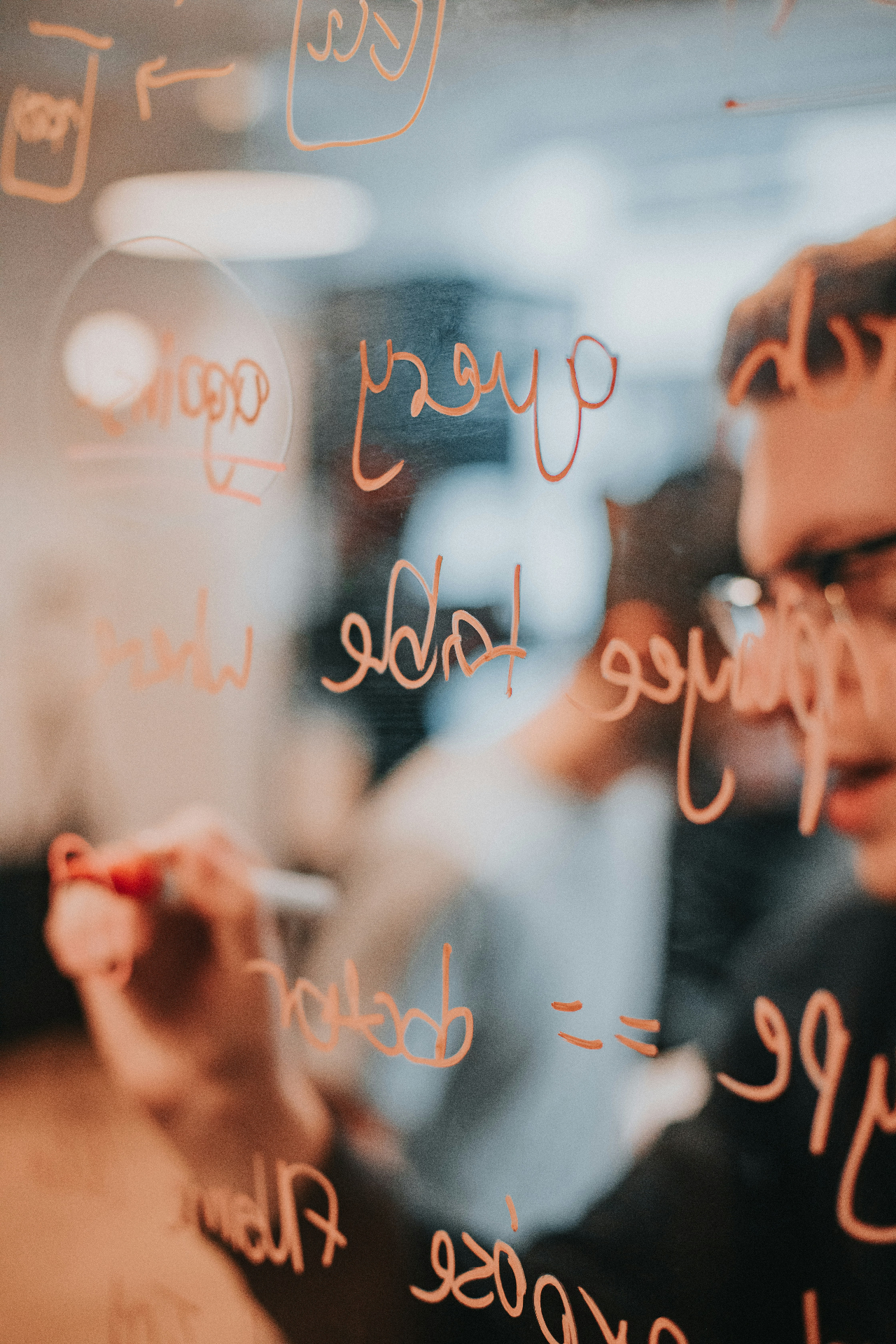 Team brainstorming on a glass whiteboard
